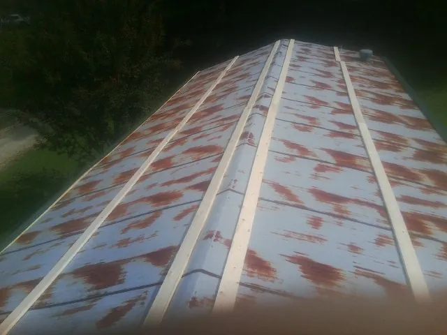 Rusted metal roof panels with new wood purlins before replacement — Storm Damage Roof Repair in Arroyo Hondo by Roofing Brothers