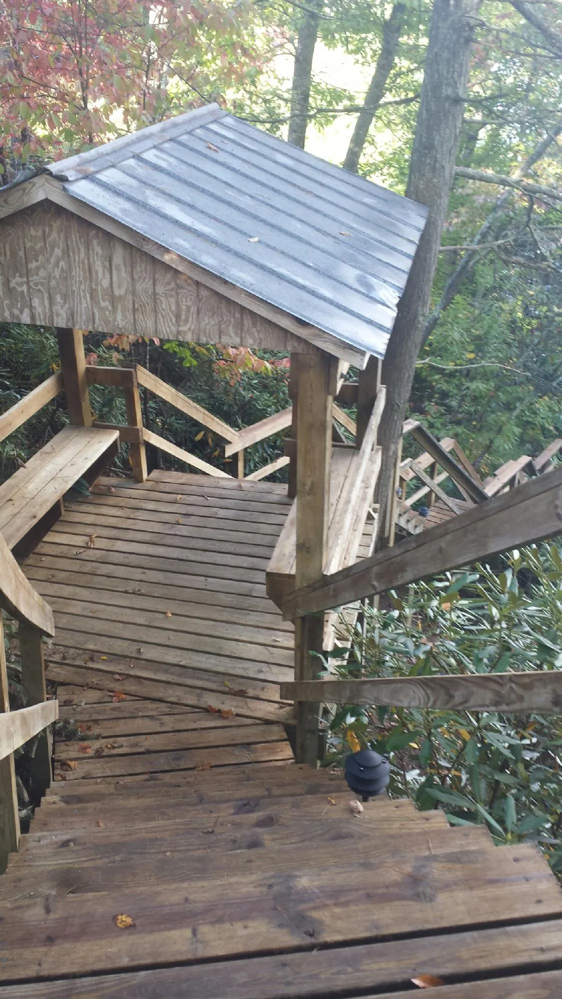 Metal roofed shelter over wooden steps on a wooded walkway — Skylight Repair & Installation work by our crew in Arroyo Hondo
