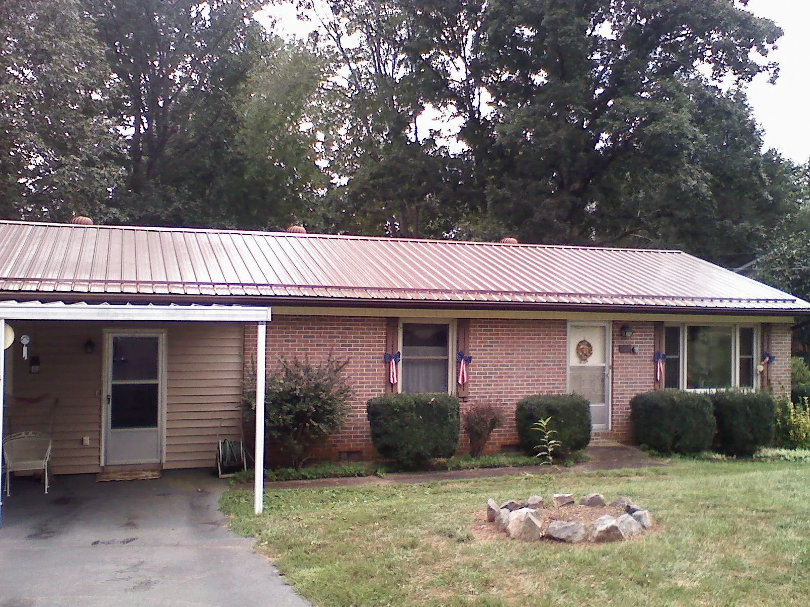 Bronze metal roof and carport on a brick ranch home — Roof Repair work by our crew in Arroyo Hondo